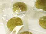 『たんぽぽ茶飴』の写真　緑色のたんぽぽ茶飴が透明の袋に個包装されています。